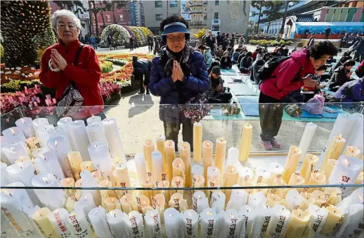  ??  ?? Hoping for the best: Women praying during a special service for their family members’ success in the college entrance exams at the Jogye temple in Seoul. — AP