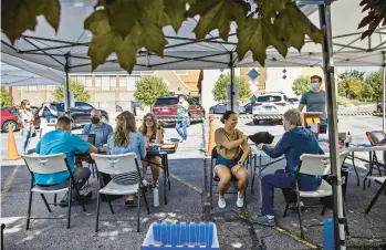  ?? KIM RAFF/THE NEW YORK TIMES ?? People receive omicron booster shots Sept. 15 at an outdoor vaccinatio­n clinic in Salt Lake City.