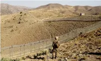  ?? Reuters file ?? A Pakistani soldier stands guard along the border fence outside the Kitton outpost on the border with Afghanista­n in North Waziristan. —