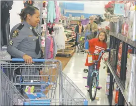  ?? STAFF PHOTOS BY JAMIE ANFENSON-COMEAU ?? Maryland Transit Authority Sergeant Aileen Pratt shops with Alyssa Garrison, 7, during “Shop with a Cop” at the Waldorf Walmart Saturday.