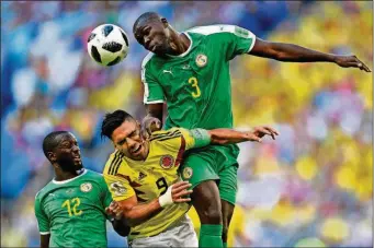  ??  ?? Colombia’s Radamel Falcao (center) jumps for the ball with Senegal’s Kalidou Koulibaly (right) and Senegal’s Youssouf Sabaly (left) during the group H match between Senegal and Colombia, Thursday in the Samara Arena in Samara, Russia.