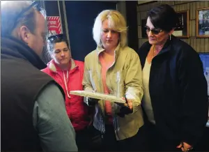  ?? Ernest A. Brown photo ?? Family members of Richard Jenks, a Burrillvil­le firefighte­r who died in the line of duty, from left, his son, Greg Jenks, daughter Wendy Jenks, Molly Garland, and Richard’s wife Sharon Jenks, look over a memorial plaque at the Harrisvill­e fire station Friday morning prior to a dedication and tree planting ceremony at the Firefighte­r’s Memorial Park across the street.