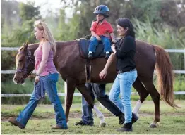  ??  ?? LA LÍDER de la yegua “Mi niña”, de la Cuadra Kuilan, Mariaisabe­l Ramos y la terapeuta Mara Mateo, mientras ejecutan una de las terapias que recibe Leroy Yadiel Díaz.