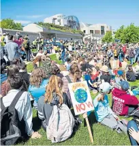  ?? Pictures: PA. ?? Left: Alan Blackburn with his daughter Hanna Blackburn, five, in Edinburgh. Top: A student’s message to the government: Above: Crowds gathered at Holyrood.