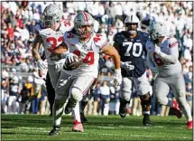  ?? ?? Ohio State defensive end J.T. Tuimoloau (44) returns an intercepti­on for a touchdown during the fourth quarter of an NCAA college football game against Penn State in State College, Pa. (AP)