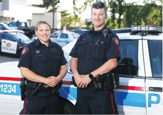  ?? JIM WELLS ?? Calgary Police Service Constables Helen Schott and Wes Burnside recently revived a driver who was overdosing while behind the wheel, leaving a trail of destructio­n on a busy southwest road.