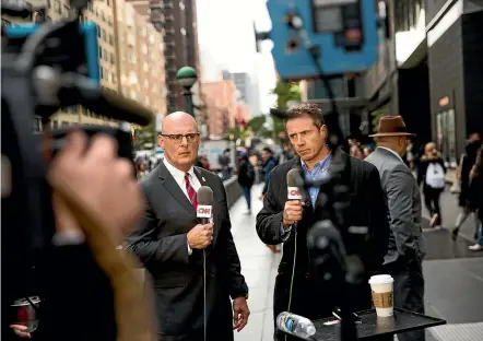 ?? AP ?? CNN correspond­ents Jeff Gagliano and Chris Cuomo speak on air in front of the Time Warner Building, where NYPD personnel were removing an explosive device.