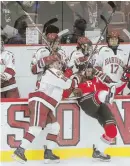  ?? STAFF PHOTOS BY NICOLAUS CZARNECKI ?? THE FIRST OF MANY: At left, Ryan Donato puts Harvard in front last night, beating RPI goalie Linden Marshall. Above, Donato checks Viktor Liljegren into the bench.