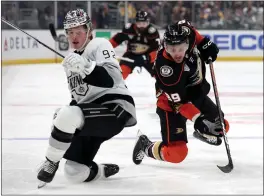  ?? HARRY HOW — GETTY IMAGES ?? The Kings' Brandt Clarke, left, and the Ducks' Sam Carrick collide at Crypto.com Arena on Saturday night. The game was still in progress when this edition went to press. For details and more on the Kings and Ducks, go to