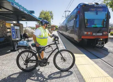  ?? DENIS POROY U-T ?? Roddy Jerome espera el trolley con su bicicleta en el Santee Town Center.