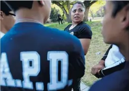  ?? Luis Sinco Los Angeles Times ?? RUBY AGUIRRE, an LAPD youth services officer, leads a cadet training session at Elysian Park this month. Cadets affectiona­tely call her “Mama Bear.”