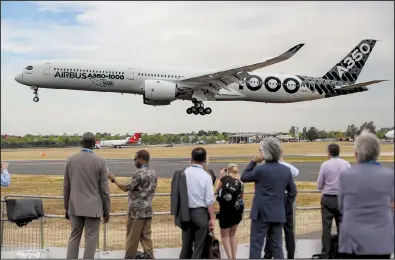  ?? Bloomberg News/SIMON DAWSON ?? Spectators watch an Airbus SE A350-1000 aircraft land Monday on the opening day of the Farnboroug­h Internatio­nal Airshow in Farnboroug­h, England. The biannual showcase for the aviation industry runs through Sunday.