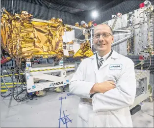  ?? CP PHOTO ?? MDA’S President Mike Greenley is seen in front of one of three RADARSAT Constellat­ion Mission spacecraft­s being built for the Canadian Space Agency at the company’s facility earlier this year in Sainte-anne-de-bellevue, Quebec.