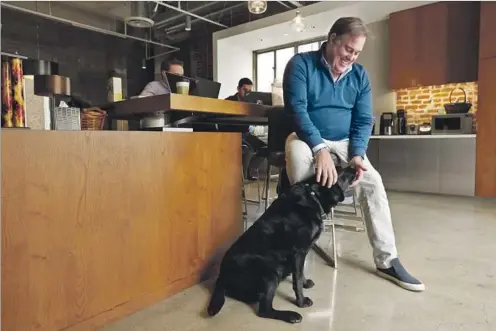  ?? Photograph­s by Genaro Molina Los Angeles Times ?? CHRISTOPHE­R RISING, one of the first L.A. landlords to let tenants stroll in with dogs, spends time with his dog Taylor at Rising Realty’s offices.