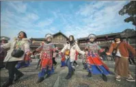  ?? HUANG XIAOHAI/ XINHUA ?? Tourists dance with local ethnic Dong people to celebrate the New Year in Danzhai county, Guizhou province.