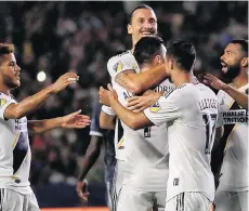  ??  ?? Zlatan Ibrahimovi­c celebrates with L.A. Galaxy teammates during a two-goal performanc­e that led Los Angeles to a 3-0 win Saturday.