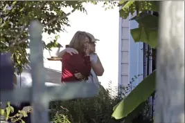  ?? CHRIS SEWARD — THE ASSOCIATED PRESS ?? Neighbors embrace at Castle Pines Drive and Sahalee Way in Raleigh, N.C., on Friday following a shooting rampage on Thursday night.