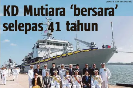  ?? [FOTO L MANIMARAN/BH] ?? Ahmad Kamarulzam­an (duduk tengah) bergambar bersama bekas Pegawai Memerintah KD Mutiara pada upacara pelucutan tauliah kapal itu di Lumut, semalam.
