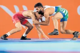  ?? PHOTO / GETTY IMAGES ?? New Zealand's Suraj Singh (left) in action against Pakistan's Ali Asad in the men's 57kg bronze medal match.