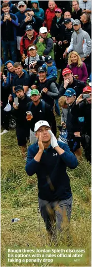  ?? AFP ?? Rough times: Jordan Spieth discusses his options with a rules official after taking a penalty drop