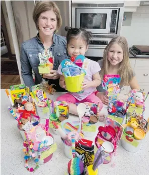  ?? WAYNE CUDDINGTON/OTTAWA CITIZEN ?? Kathy Patterson recruits daughters Ruby, 3, and Phoebe, 10, to help her create themed loot bags.
