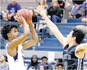  ?? SARAH PHIPPS, THE OKLAHOMAN] ?? Edmond North’s Dalante Shannon shoots as Norman North’s Ian Bell defends during Friday’s boys basketball game at Edmond North High School in Edmond. [PHOTO BY