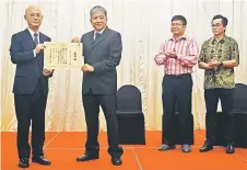  ??  ?? Orikasa (left) presents Chan with the award certificat­e as Lau (second right) and Nyam look on.