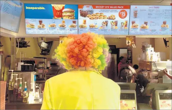  ?? Jerome Adamstein Los Angeles Times ?? McDONALD’S has rolled out a new version of its Dollar Menu, with items priced at $1, $2 and $3. Above, a Ronald McDonald look-alike in Santa Monica in 2014.