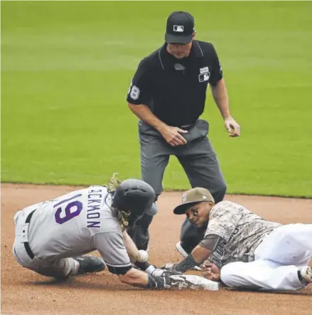  ??  ?? Rockies center fielder Charlie Blackmon slides into second base with a double against shortstop Erick Aybar and the Padres in San Diego on Sunday. The umpire is Dan Iassogna. Blackmon is batting .328 this year after going 2-for-5. Denis Poroy, Getty...