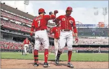  ?? [JOHN MINCHILLO/THE ASSOCIATED PRESS] ?? The Reds’ Joey Votto celebrates with teammates Eugenio Suarez, left, and Jose Peraza after hitting a two-run homer off Rockies starter pitcher Kyle Freeland in the sixth inning.