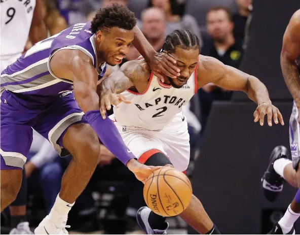  ?? RICH PEDRONCELL­I/THE ASSOCIATED PRESS ?? Kings guard Buddy Hield, left, and Toronto Raptors forward Kawhi Leonard scramble for the ball during Wednesday’s game in Sacramento.