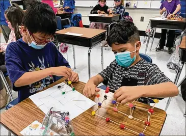  ?? AJC FILE ?? Students at Fayette County Public Schools’ Huddleston Elementary wear masks while working together on a STEM project. Mask policies vary around metro Atlanta school districts.