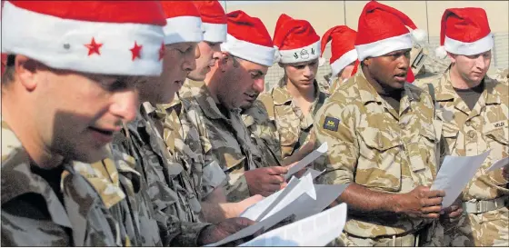  ??  ?? FADING VOICES: British soldiers at a morale-boosting Christmas carol service held at their camp near Basra, Iraq, on December 25, 2008