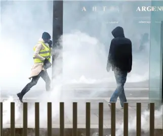  ?? REUTERS ?? PROTESTERS walk through tear gas during a demonstrat­ion of the “yellow vests” movement in Nantes, France in this Jan. 5 photo.