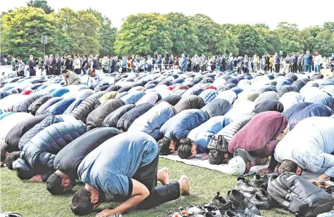  ?? — AFP photos ?? Muslim men pray in a park near the Al Noor mosque, shortly after a two minutes silence held in memory of the twin mosque massacre victims in Christchur­ch.