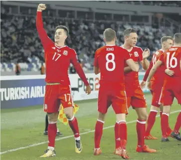  ??  ?? Tom Lawrence salutes the travelling Welsh fans as he celebrates his winning goal in Tbilisi.