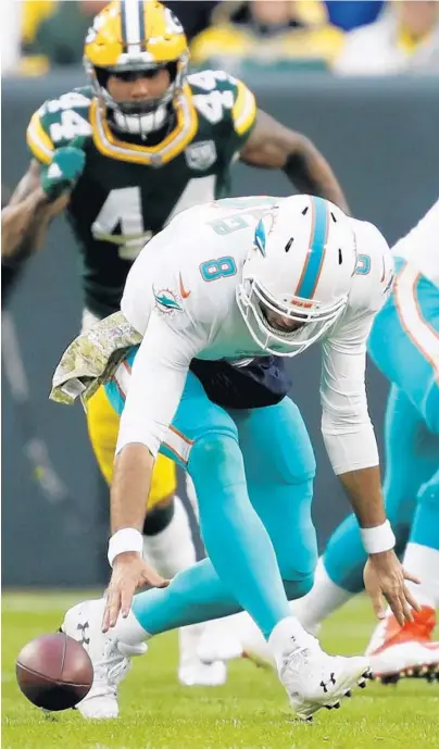  ?? MATT LUDTKE/AP ?? Dolphins quarterbac­k Brock Osweiler fumbles the ball during the first half of Sunday’s 31-12 loss to the Packers. He completed 23 of 37 passes for 213 yards, did not throw a touchdown, had two turnovers (1 intercepti­on, 1 fumble) and was sacked six times.