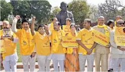  ?? — PTI ?? Telugu Desam MPs protest in front of Mahatma Gandhi’s statue in Parliament during second phase of Budget session in New Delhi on Thursday .