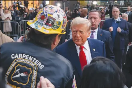  ?? YUKI IWAMURA / ASSOCIATED PRESS ?? Former President Donald Trump speaks April 25 with workers at the work site of the new Jpmorgan Chase headquarte­rs in midtown Manhattan in New York.