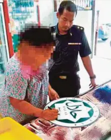  ??  ?? PEGAWAI KPDNHEP merampas logo halal tamat tempoh yang digunakan premis memproses makanan ringan.