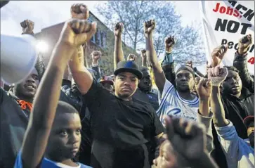  ?? Drew Angerer
Getty Images ?? PROTESTERS HOLD a vigil for Freddie Gray in Baltimore this week. According to an autopsy, Gray died from an injury that severed his spinal cord after police arrested him. Six officers have been suspended.