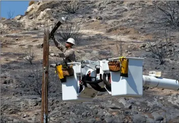  ?? AP PhoTo/rIch PeDroncell­I ?? In this 2016 file photo, Robert Delgado, a lineman for Southern California Edison, works on a power line at fire ravaged South Lake, Calif.