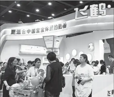  ?? PROVIDED TO CHINA DAILY ?? Visitors at a Feihe Dairy milk formula booth at an exhibition in Zhengzhou, Henan province.