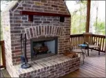  ??  ?? Ideal for outdoor living, the covered back deck has a brick woodburnin­g  replace.