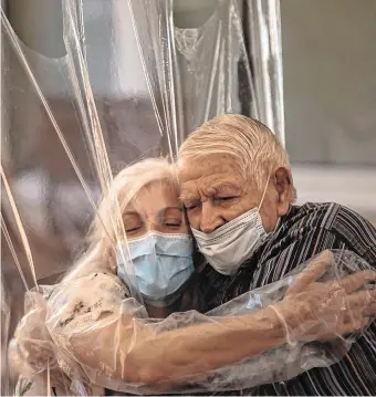  ?? PHOTO: EMILIO MORENATTI/AP ?? Reunited: Dolores Reyes hugs her father, Jose Reyes, for the first time in months as visits resume at a Barcelona nursing home.