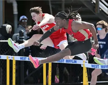  ?? Photos by Justin Guido/For the Post-Gazette ?? Penn Hills’ Achan Green, right, races to victory in the boys 110-meter hurdles Saturday at the Tri-State Track Coaches Associatio­n Invitation­al.