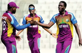  ?? PHOTO
COURTESY OF
ICC ?? Chemar Holder (right) celebrates taking a wicket during the ICC Under-19 World Cup final between West Indies Under-19 and India at Sher-e-Bangla National Cricket Stadium, Mirpur, Dhaka, on Sunday, February 14, 2016.