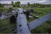  ?? BERNAT ARMANGUE — THE ASSOCIATED PRESS ?? Oleksiy Polyakov, right, and Roman Voitko check the remains of a destroyed Russian helicopter lie in a field in the village of Malaya Rohan, Kharkiv region, Ukraine, Monday.