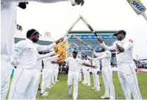  ?? PHOTO: REUTERS ?? The teammates of Sri Lanka spinner Rangana Herath form a guard of honour as he leaves the field after taking his 100th test wicket at Galle, in his farewell appearance, against England yesterday.