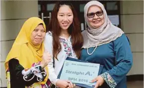  ?? ZULFADHLI ZULKIFLI
PIC BY ?? Synchronis­ed swimmer Veronica Lee (centre), from SMK Aminuddin Baki, with the school’s principal, Siti Sarimah Shaik Abdul Rahman (right), and a teacher at the school in Kuala Lumpur yesterday.